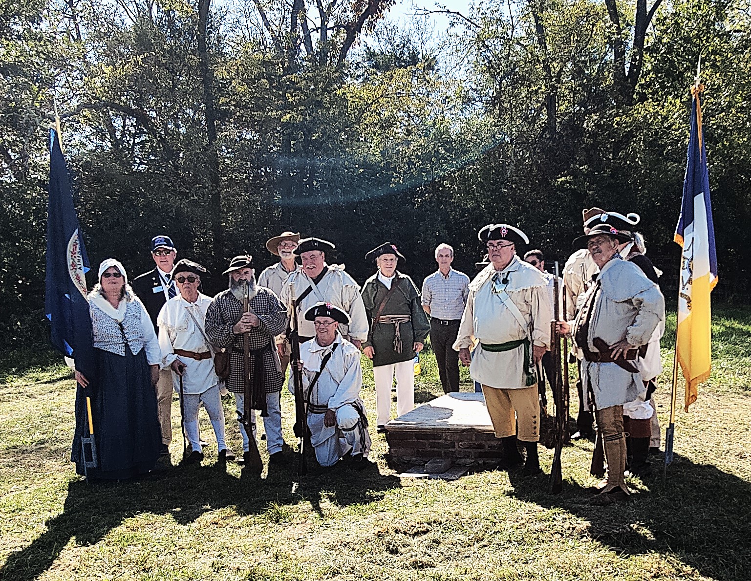 Group photo of participants at the ceremony; many in colonial attire.