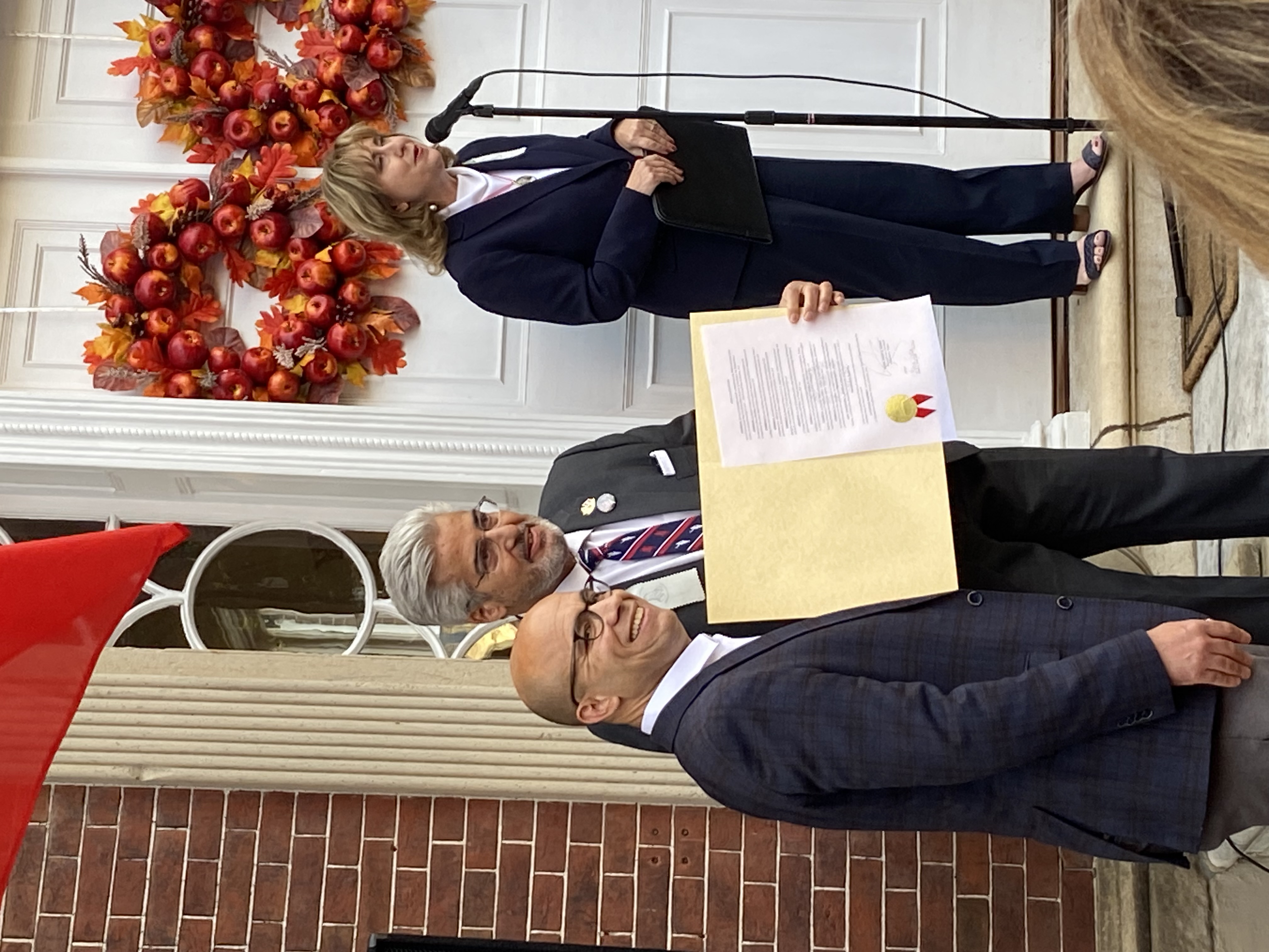 Mayor Justin Wilson offers proclamation to AFL Executive Director Chuck Schwam while Gretchen Bulova speaks to the crowd.